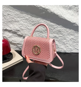 Detail of pink tweed handbag with gold M-logo buckle and leather shoulder strap