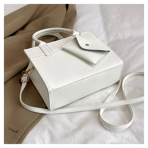 Detail of white PU leather square handbag with detachable strap and small envelope pouch