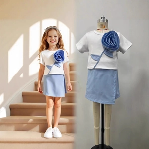 Details des Mädchen-Sommersets mit 3D-Rose auf weißem T-Shirt und blauem Rock