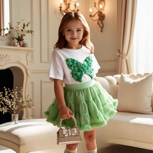 Detail of 3D butterfly floral applique on girl's white t-shirt and green mesh tutu skirt