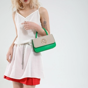 Sac à main bicolore vert et beige avec logo M doré porté par un mannequin de mode