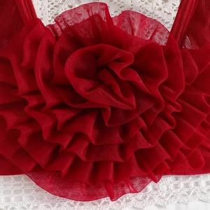Close-up of handmade 3D red mesh flower detail on girl's tutu dress with lace texture