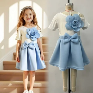 Detail of white girls' t-shirt with 3D blue flower and matching bow skirt set