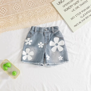 Détail du short en jean bleu clair pour fille avec fleurs et bords effilochés