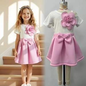 Detail of girls summer set showing 3D pink rose applique and large bow on the skirt