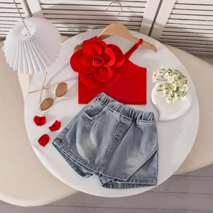 Close-up of girls red one-shoulder top with 3D floral detail and denim shorts