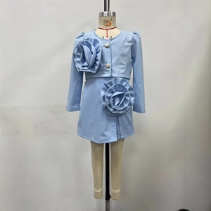 Detail of light blue girls' set featuring 3D floral rosettes and stylish silver buttons