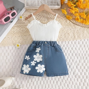 Flachbild eines weißen Rüschentops und blauer Jeans-Shorts mit großem Blumendruck