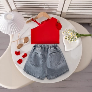 Flat lay of girl's red one-shoulder top and light blue denim shorts with pockets