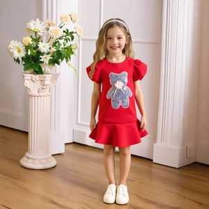 Close-up of red short sleeve dress featuring silver sequin bear and floral accents