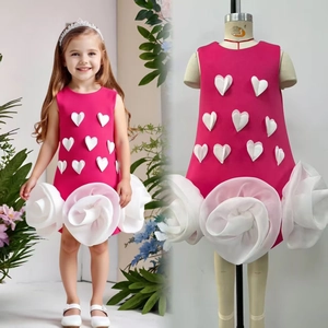 Detail of fuchsia girls' dress featuring 3D heart appliques and oversized tulle roses