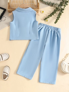 Flat lay of light blue sleeveless suit set for girls with accessories and elegant decor