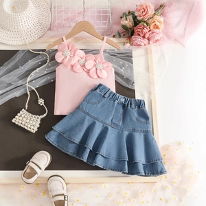 Detail of pink ribbed tank top with 3D fabric flowers and layered denim cake skirt