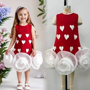 Detail of red sleeveless girls dress featuring 3D white heart accents and a rose flower hem