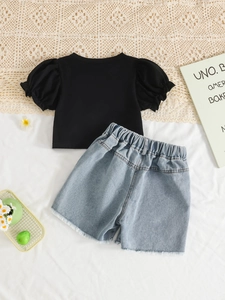 Ensemble fille avec t-shirt noir à manches bouffantes et short en jean délavé à marguerites