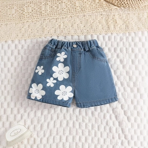 Detailansicht der Kinder-Jeans-Shorts mit weißen Blumenmustern und elastischem Bund