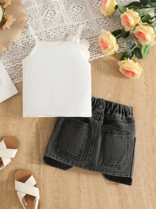 Vue à plat d'un caraco blanc et short en jean délavé avec accessoires d'été pour fille