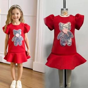 Detail of red girls' dress with sequin bear embroidery and puffy sleeves on model and mannequin