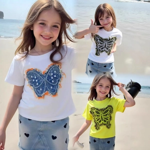 Détail de l'ensemble été fille avec t-shirt papillon et jupe en jean à motif coeur