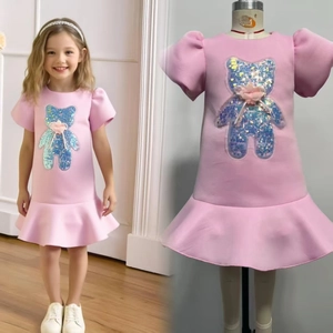 Detail of pink girls princess dress featuring sequin bear patch and ruffled mesh flower