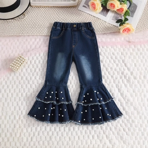 Detail of girls' flared denim pants with elastic waist and white pearl bead embellishments