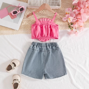 Détail à plat du débardeur rose plissé et du short en jean effiloché pour filles