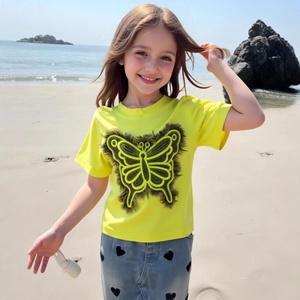 Détail de la broderie papillon sur le t-shirt jaune pour filles en coton pour l'été