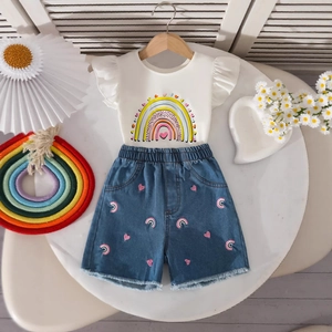 Flat lay of girls' white rainbow sleeve top and denim shorts with embroidery