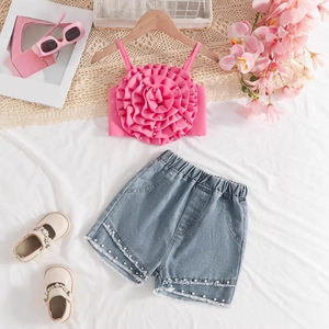 Détail du haut à fleurs roses avec perles et short en jean effiloché pour filles