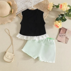 Detail of girls' black lace-trimmed vest and mint green denim shorts with summer accessories