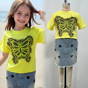 Détail du t-shirt jaune avec patch papillon et jupe en jean à imprimé cœur