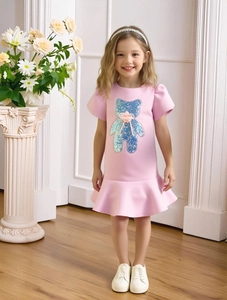 Pink girls puff sleeve dress featuring sequin bear motif and ruffled fishtail hemline