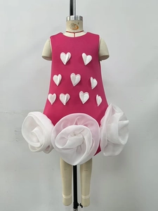Detailed view of pink girls dress with 3D heart appliqués and organza rose hem