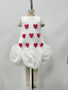 Detailed view of girls' white sleeveless dress featuring 3D red hearts and large fabric roses