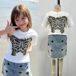 Détail du t-shirt blanc pour fille avec papillon et jupe en jean brodée de petits cœurs