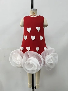 Detail of red girl dress featuring 3D heart appliqués and white organza rose hem
