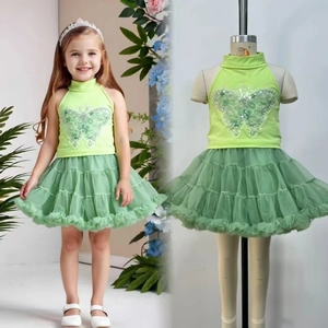 Close-up of girls' green tutu skirt and halter top with sequin butterfly embroidery
