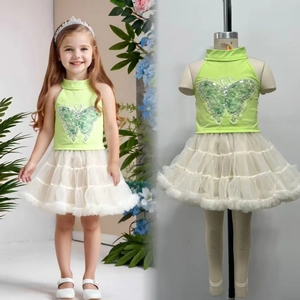 Detail of girls' neon green halter top with sequin butterfly and white tutu skirt