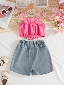 Ensemble d'été pour filles avec haut à volants rose et short en jean sur fond blanc