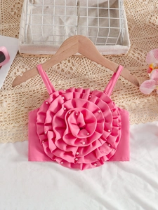 Haut rose pour fille avec fleurs 3D et perles décoratives sur un cintre en bois