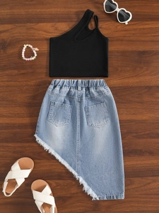 Ensemble été fille avec débardeur noir asymétrique et jupe en jean à franges sur bois