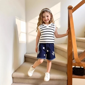 Detail of girls' striped V-neck tank top and denim shorts with star embroidery and frayed edges
