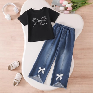 Detail of girl's denim pants featuring a stylish V-slit hem and cute white bow accents