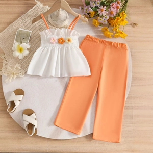 Detail of girls' summer set with 3D floral appliques on pleated top and wide-leg pants