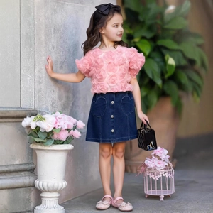 Detail of girls' pink short sleeve top with 3D roses and denim heart pocket skirt