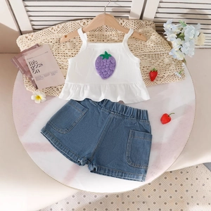Détail d'ensemble d'été fille avec débardeur blanc fraise et short en jean bleu
