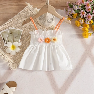 Detail of white girls camisole featuring colorful 3D woven flowers and orange straps