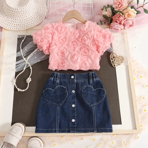 Detail of pink rose texture top and denim skirt with heart pockets for girls
