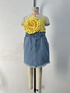 Détails du haut jaune à fleurs avec perles et de la jupe en jean avec ourlet effiloché