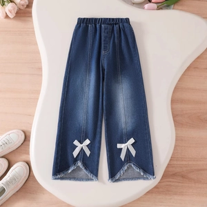 Detail of girls' dark wash denim wide-leg pants with elastic waist and white bow accents